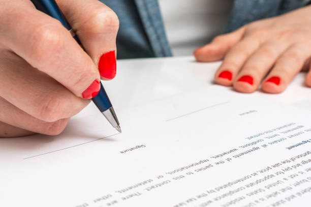 istock Woman with ballpoint pen signing contract document 656909642
