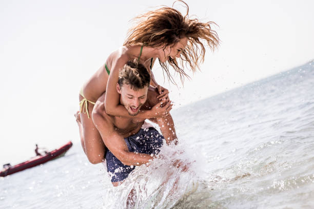 istock Young cheerful couple playing in the sea. 656919712