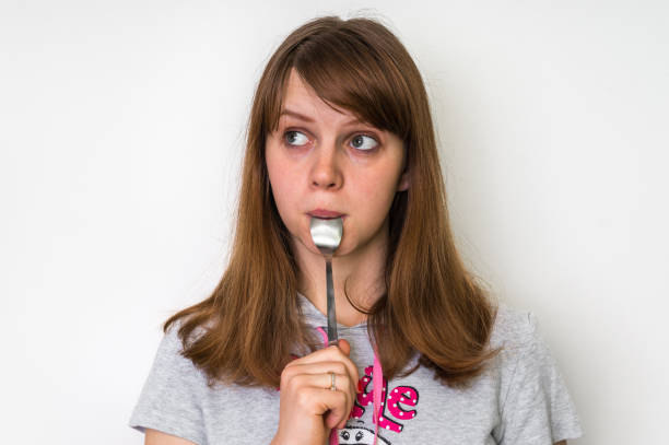 istock Young beautiful woman with spoon in mouth 656923168