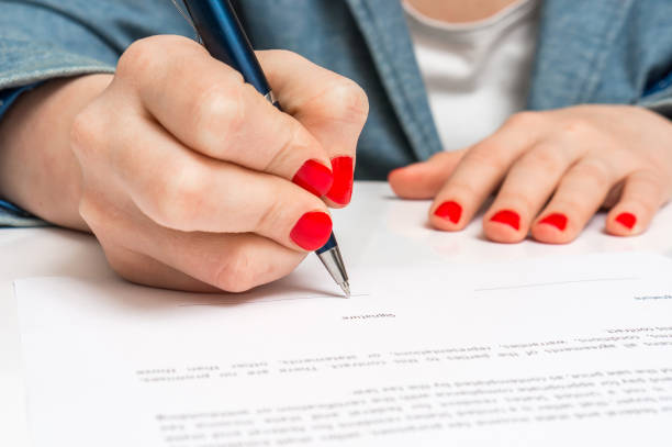 istock Woman with ballpoint pen signing contract document 656926258