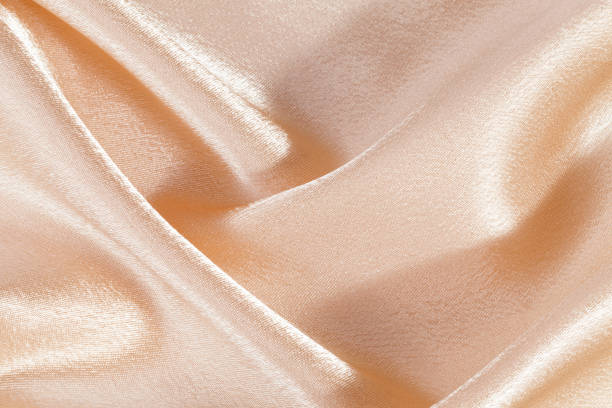 istock Silk background, texture of beige  shiny fabric, close up 656936040