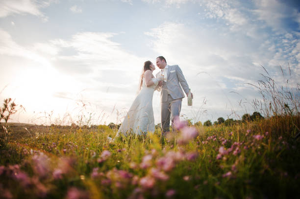 istock Newlyweds on sunset with flowers 656937176