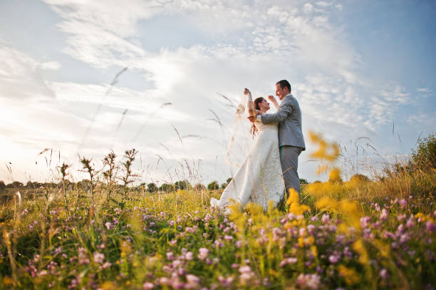 istock Newlyweds on sunset with flowers 656937220