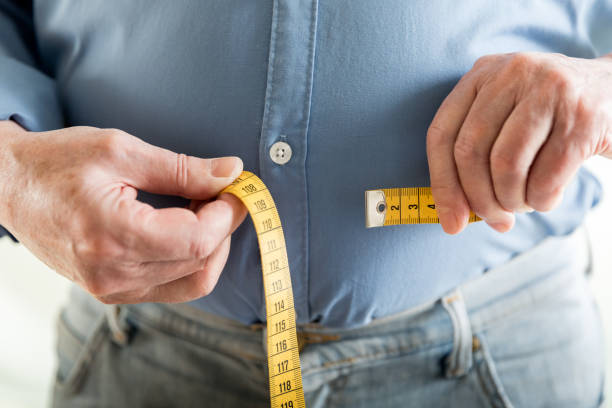 overweight - measuring waist imagens e fotografias de stock
