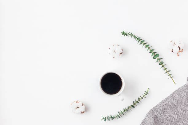 istock Workspace with cup of coffee, cotton flowers, eucalyptus branches, plaid 656954130