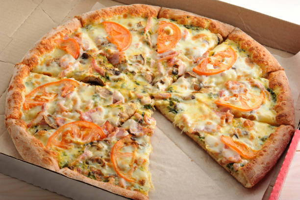 istock pizza cut into slices with mushrooms, tomatoes, cheese and bacon 656957992