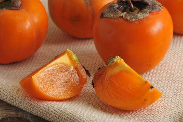 istock persimmon whole and cut into pieces on canvas 656961476