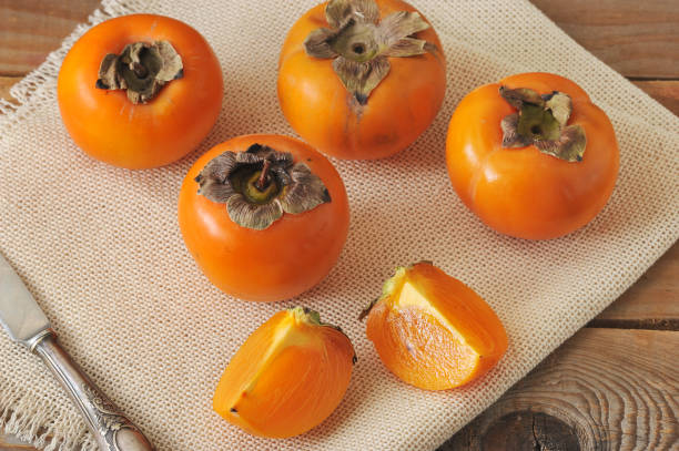 istock persimmon whole and cut into pieces on canvas 656962614