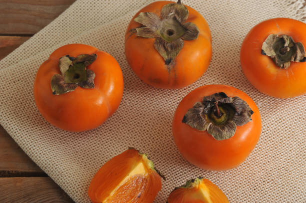istock persimmon whole and cut into pieces on canvas 656965180
