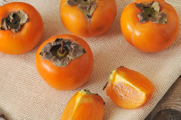 istock persimmon whole and cut into pieces on canvas 656965422