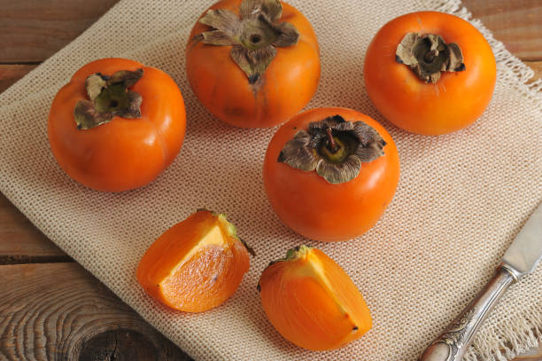 istock persimmon whole and cut into pieces on canvas 656968072