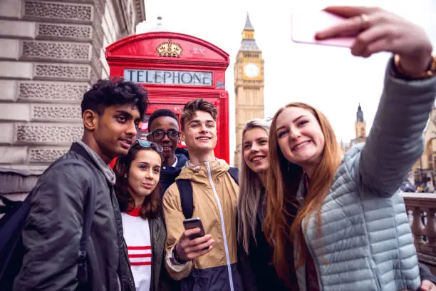 Group of young teenagers enjoying a school trip in London, they're visiting Westminster areas.