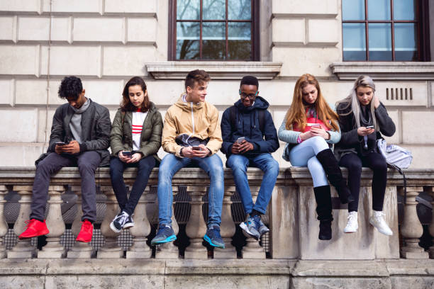 Teenagers students using smartphone on a school break Group of young teenagers students using smartphone on a school break teenager stock pictures, royalty-free photos & images