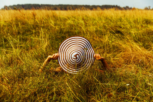 Woman in sunhat on green field