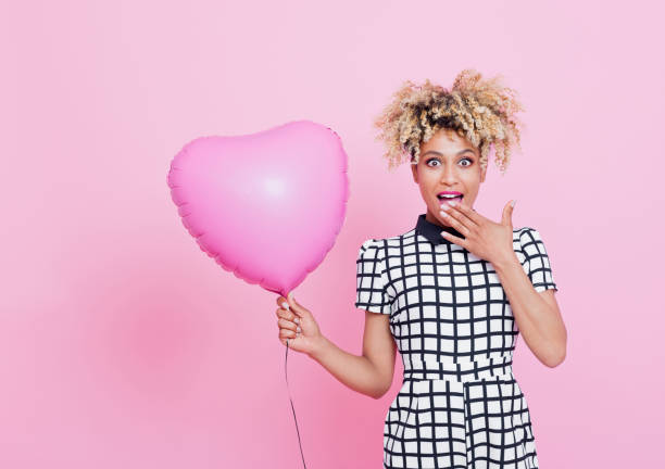 istock Afro american woman holding pink balloon 656983748