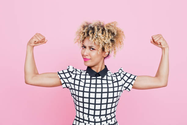 Confident afro american young woman flexing arms