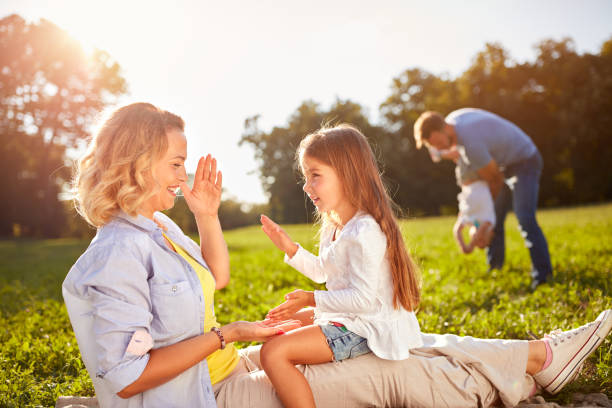 istock Happy woman with daughter playing on picnic 656990562