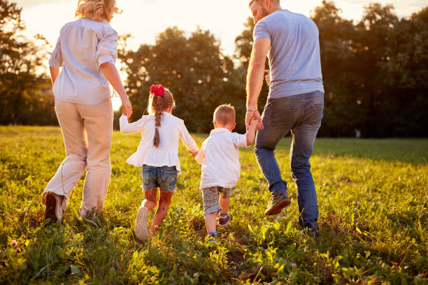 istock Parents with children walking in nature, back view 656992602