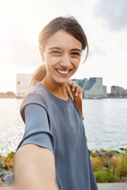 istock cheerful young woman talking selfie and smiling 656993066