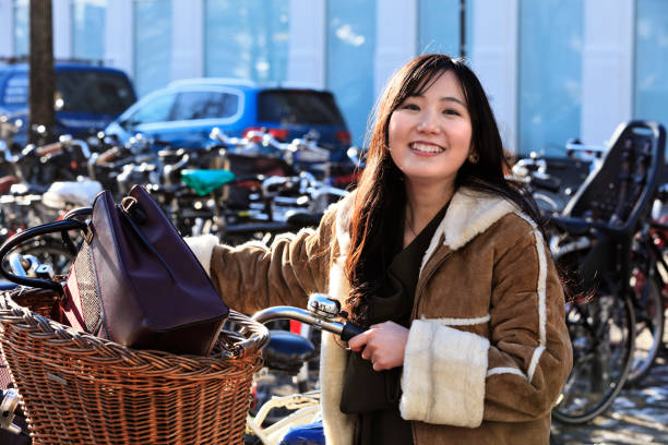 Happy japanese woman using bycle in Copenhagen, Denmark