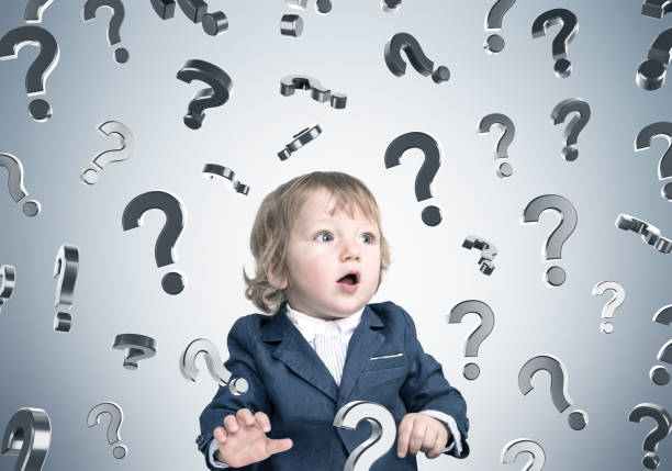istock Baby boy and question marks on gray wall 657006926