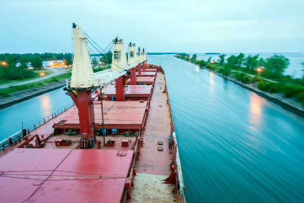 Ship Sailing Detroit Canal in Usa - Passing canal Ship Sailing Detroit Canal in Usa - Passing canal with canal lights - long exposure bulk carrier stock pictures, royalty-free photos & images