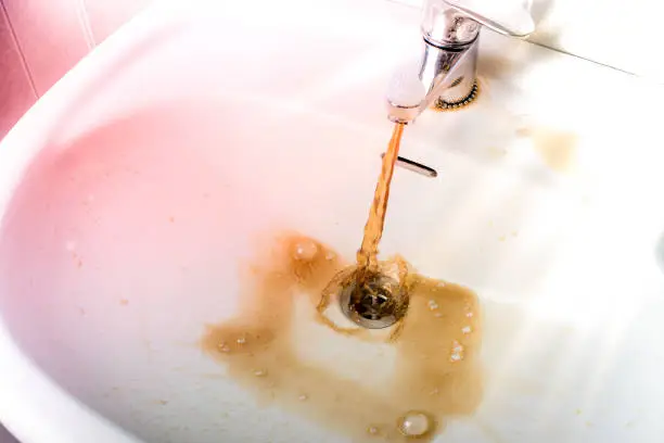 Photo of Dirty brown water running into a sink