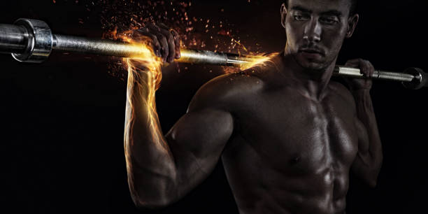 sport creativo. ritratto ravvicinato di bodybuilder professionista con fuoco - abdominal muscle muscular build barbell bicep foto e immagini stock