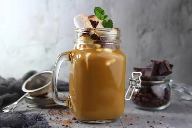 milk-chocolate smoothie in a mug with marshmallows, cinnamon and mint leaf