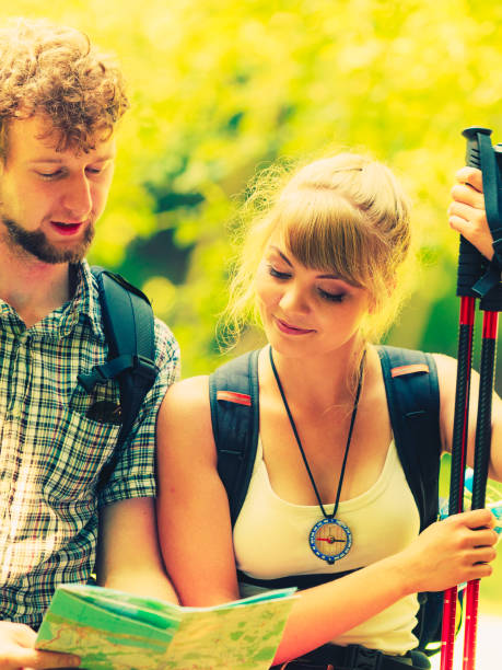 istock Hikers backpackers couple reading map on trip. 657028728