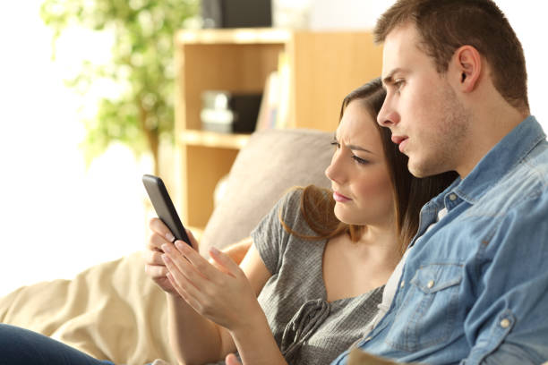 istock Upset couple checking content in a phone 657035520