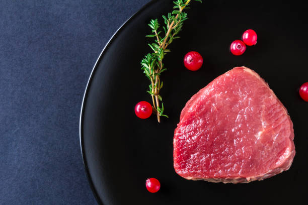 istock Raw meat on black plate and dark background 657038704