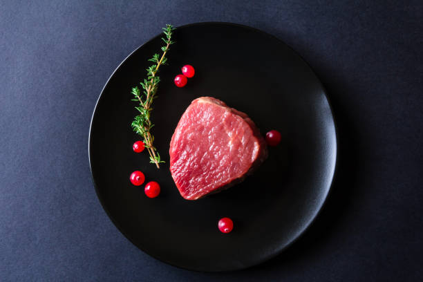 istock Raw meat on black plate and dark background 657049288