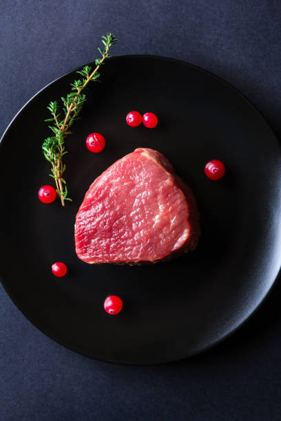 istock Raw meat on black plate and dark background 657052402