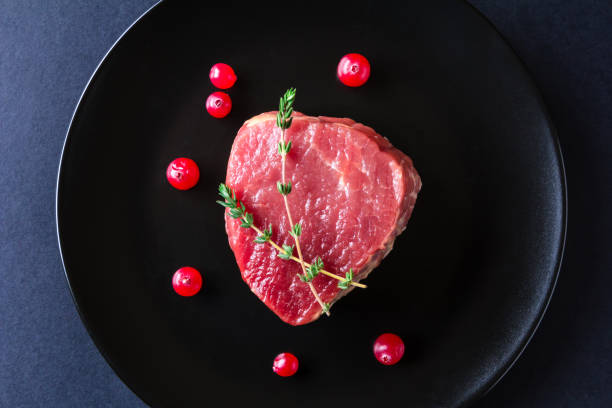 istock Raw meat on black plate and dark background 657059274