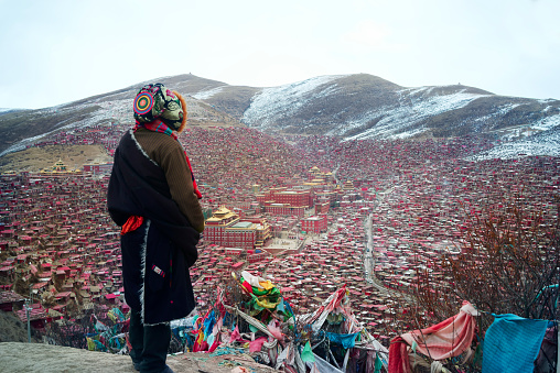 Tibetan people standing on the mountain, the background is the Buddhist College of Tibet