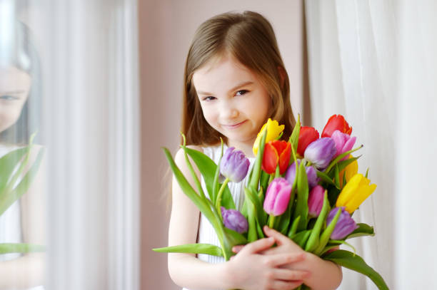 istock Adorable smiling little girl with tulips 657063630