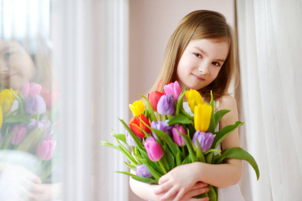 istock Adorable smiling little girl with tulips 657063676