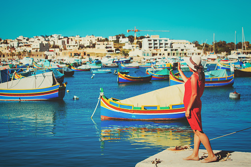 travel concept - tourist making photo of tranditional maltese boats