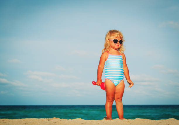 cute little girl play with sand on tropical beach