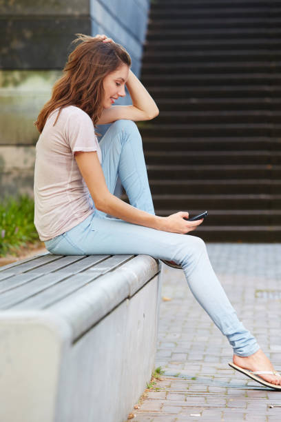 istock Beautiful female using cell phone outdoors 657079660