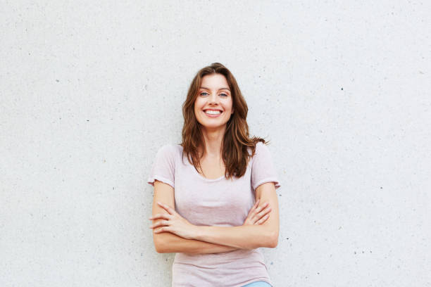 istock attractive young woman smiling against white wall 657079662