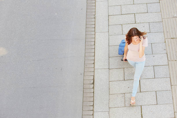 istock woman walking with bag and talking on cell phone 657079740