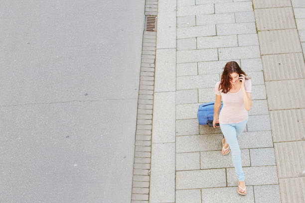 istock woman walking with bag and talking on mobile phone 657079838