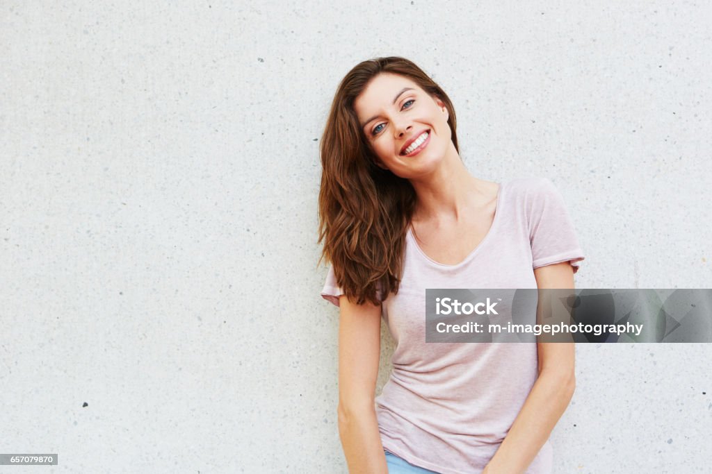 atractiva joven sonriendo contra fondo blanco - Foto de stock de Mujeres libre de derechos