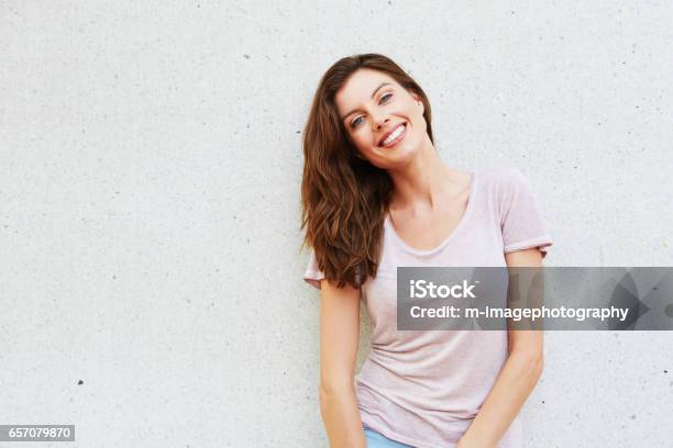 Atractiva Joven Sonriendo Contra Fondo Blanco Foto de stock y más banco de imágenes de Mujeres - Mujeres, Una sola mujer, 30-39 años