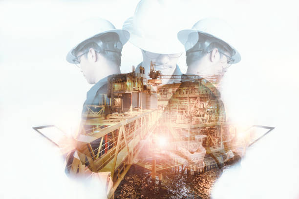 Double exposure of Engineer or Technician man with safety helmet operated platform or plant by using tablet with offshore oil and gas platform background for oil and gas business concept stock photo