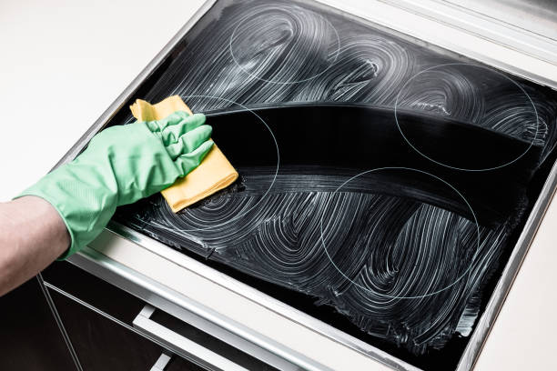 Man's hand in green protective glove with yellow rag cleaning cooker at home kitchen. Housework and housekeeping concept Man's hand in green protective glove with yellow rag cleaning cooker at home kitchen. Housework and housekeeping concept cleaning stove domestic kitchen human hand stock pictures, royalty-free photos & images