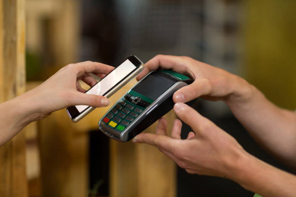 istock Woman making a payment by using NFC technology in the grocery store 657106774