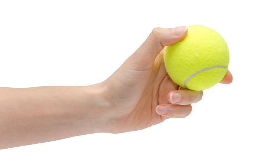 hand of young girl holding tennis ball. Isolated on white background